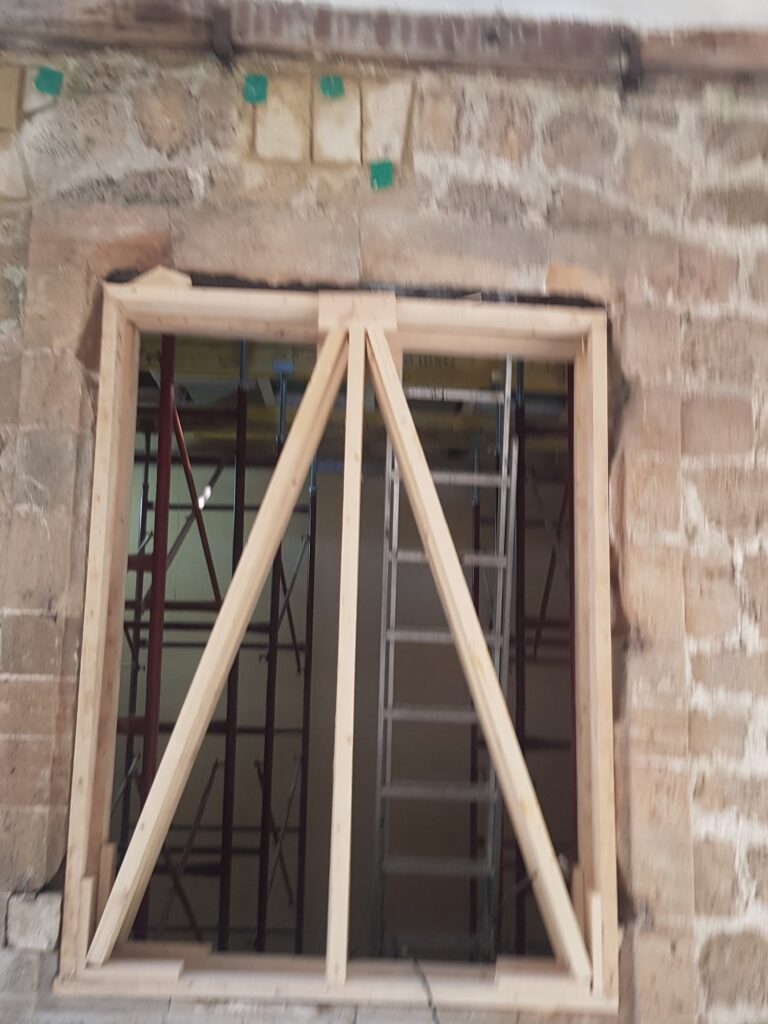 חלון קשתי משוחזר עם סבכת עץ וברזל מעוטר