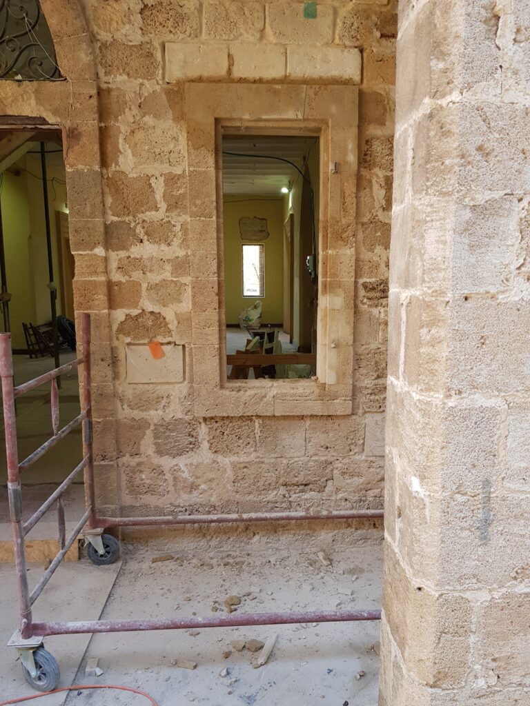 פתח כניסה קשתי משוחזר עם דלת עץ