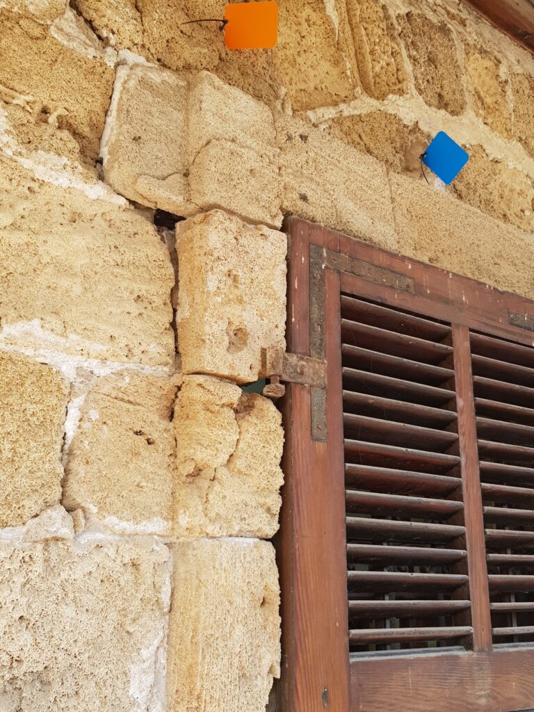 חלון עם תריסי עץ בקיר אבן כורכר