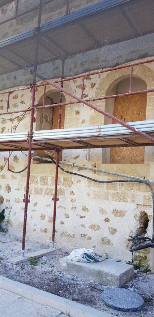 מבט רחב על הבניין עם פיגומים בשלבי שימור