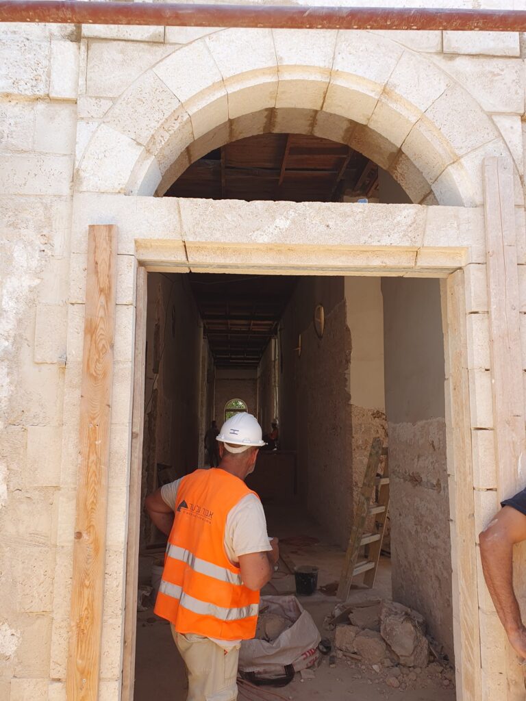 פועל במסדרון קשתות בשלבי שיקום