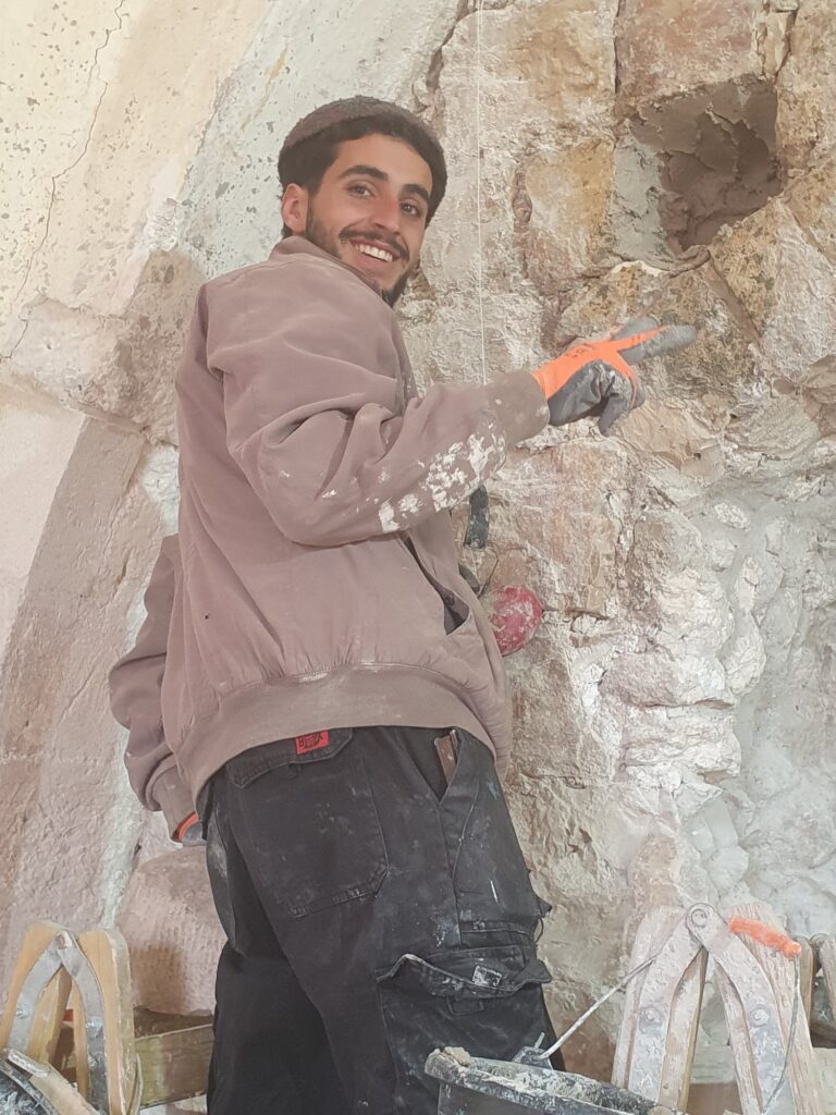 פועל בעבודת אבן בשיקום הבניין