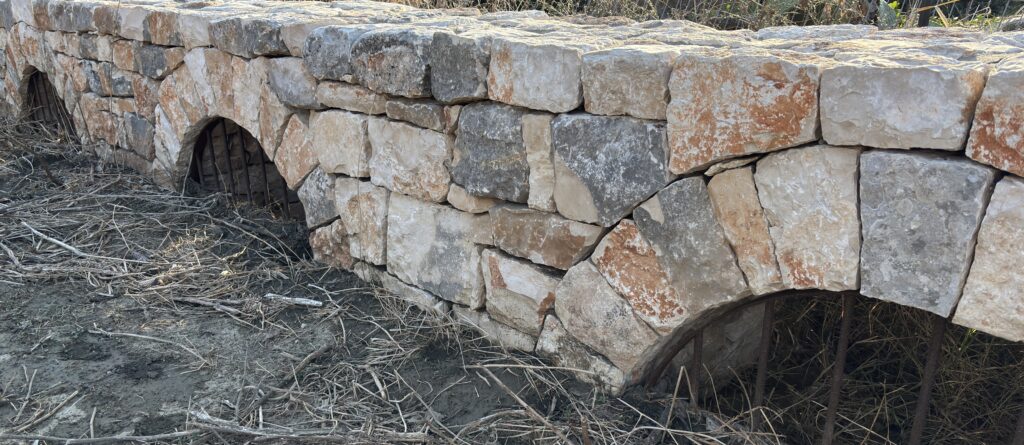 רצף קשתות ניקוז אבן בנויות ביד בקיר תמך בבנייה יבשה, פרויקט הנוף בכרם מהר"ל