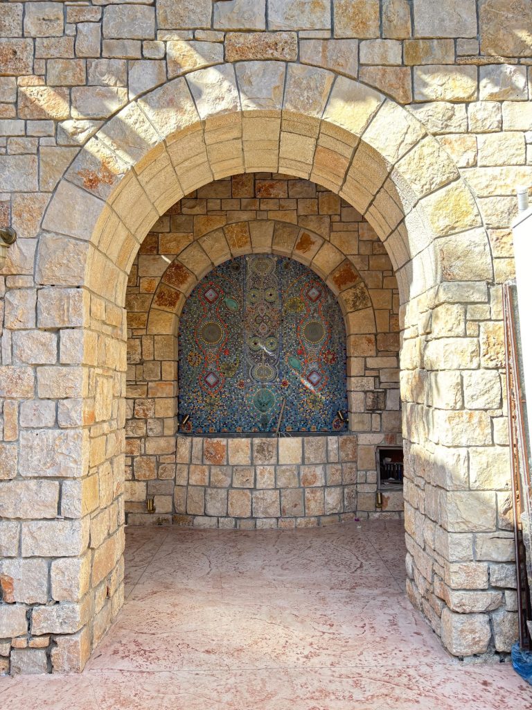 כניסה עם קשת אבן מעוטרת וגומחת פסיפס — בית האבן במשמר איילון