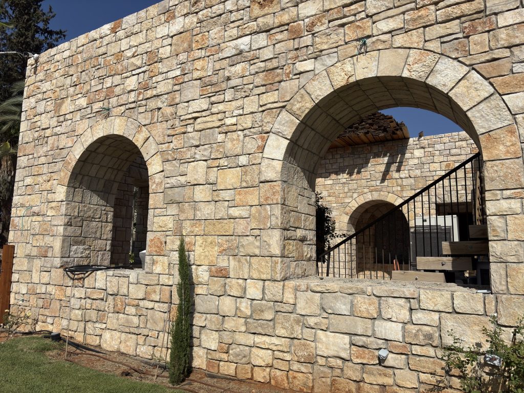 קיר אבן עם שני פתחי קשת וברוש — בית האבן במשמר איילון