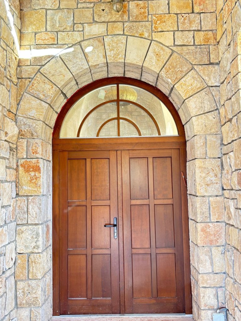 דלת עץ כפולה במסגרת קשת אבן — בית האבן במשמר איילון