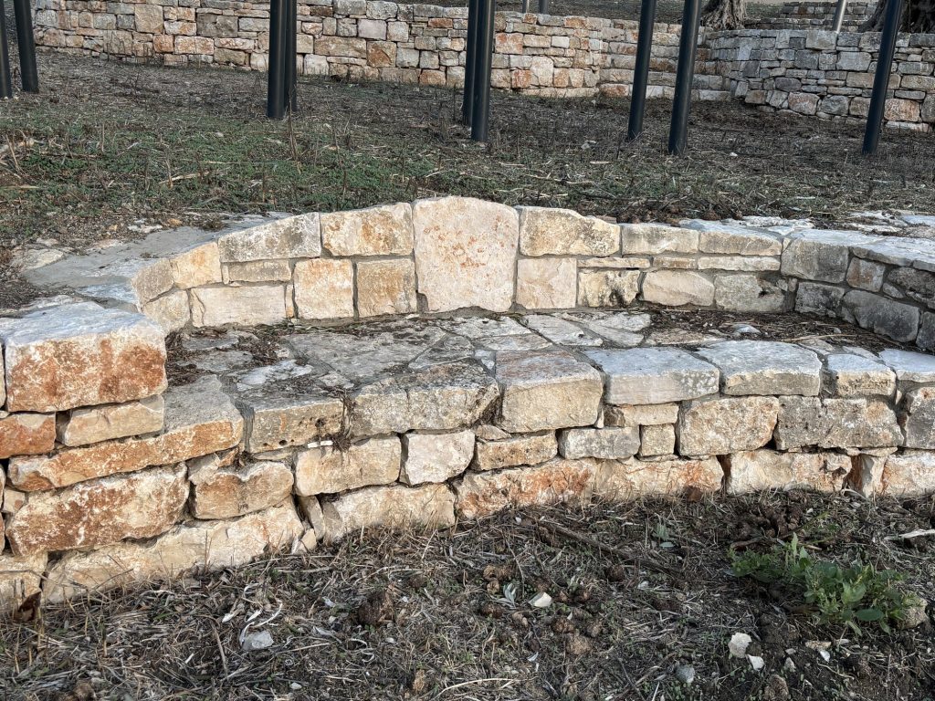 ספסל אבן בנוי בתוך קיר הטרסה — פרויקט הנוף בכרם הזיתים