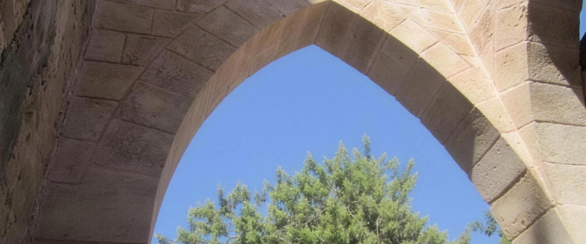 קשתות אבן כורכר מחודדות בבית הבאר, המושבה הטמפלרית שרונה